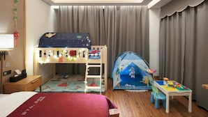 A child’s room with a bunk bed, a play tent, and a small table with toys.