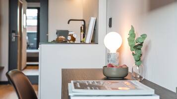 Una cocina moderna con una zona de comedor. Hay un bol con una vela y una planta sobre la mesa.