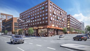 A multi-story hotel with a brick facade, large windows, and a prominent entrance with a sign.