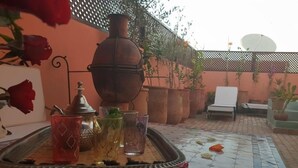 A tray with glasses and a pot on a tiled patio. - Dar Halima (Marrakech)