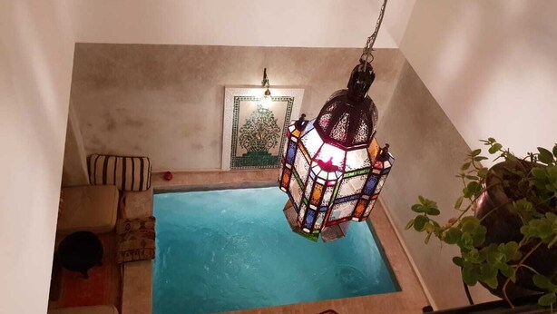 A small indoor swimming pool with a colorful hanging lantern above it. - Dar Halima (Marrakech)