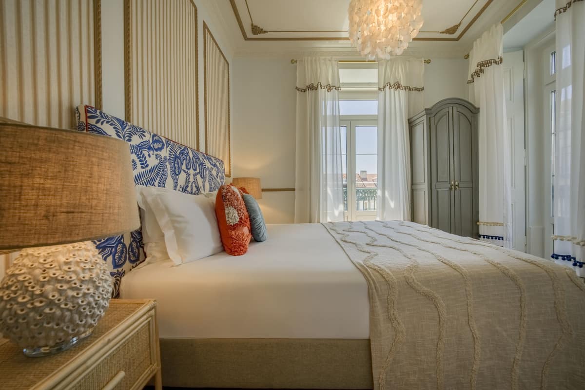 Une chambre bien rangée, avec un grand lit, une table de chevet avec une lampe et une armoire.