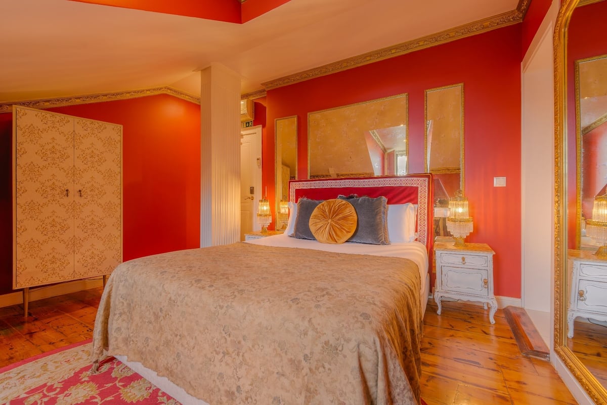 Une chambre à coucher avec un grand lit, une armoire et un miroir.