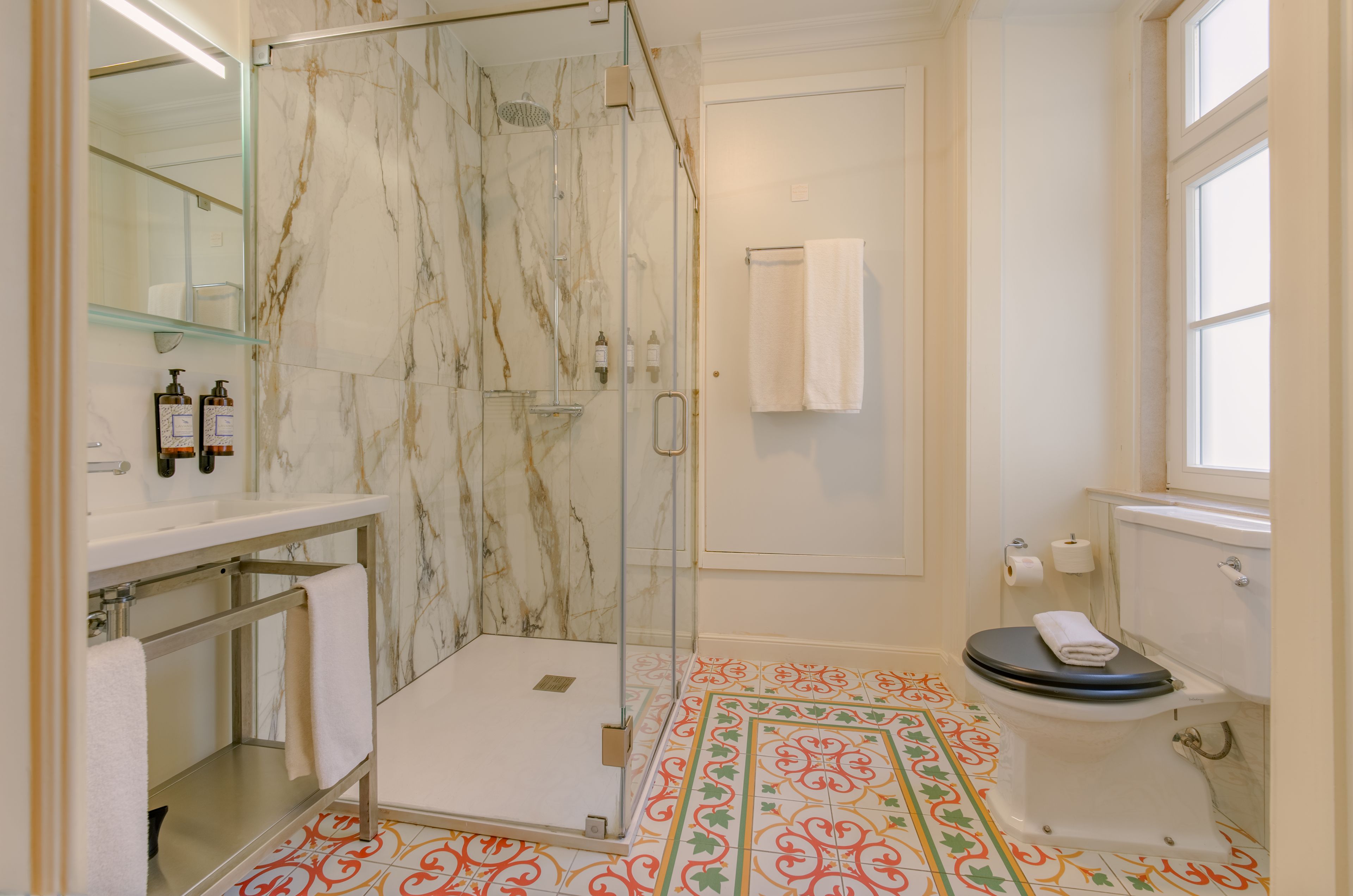 Une salle de bain avec une douche à parois de verre, des toilettes et un lavabo avec un miroir.