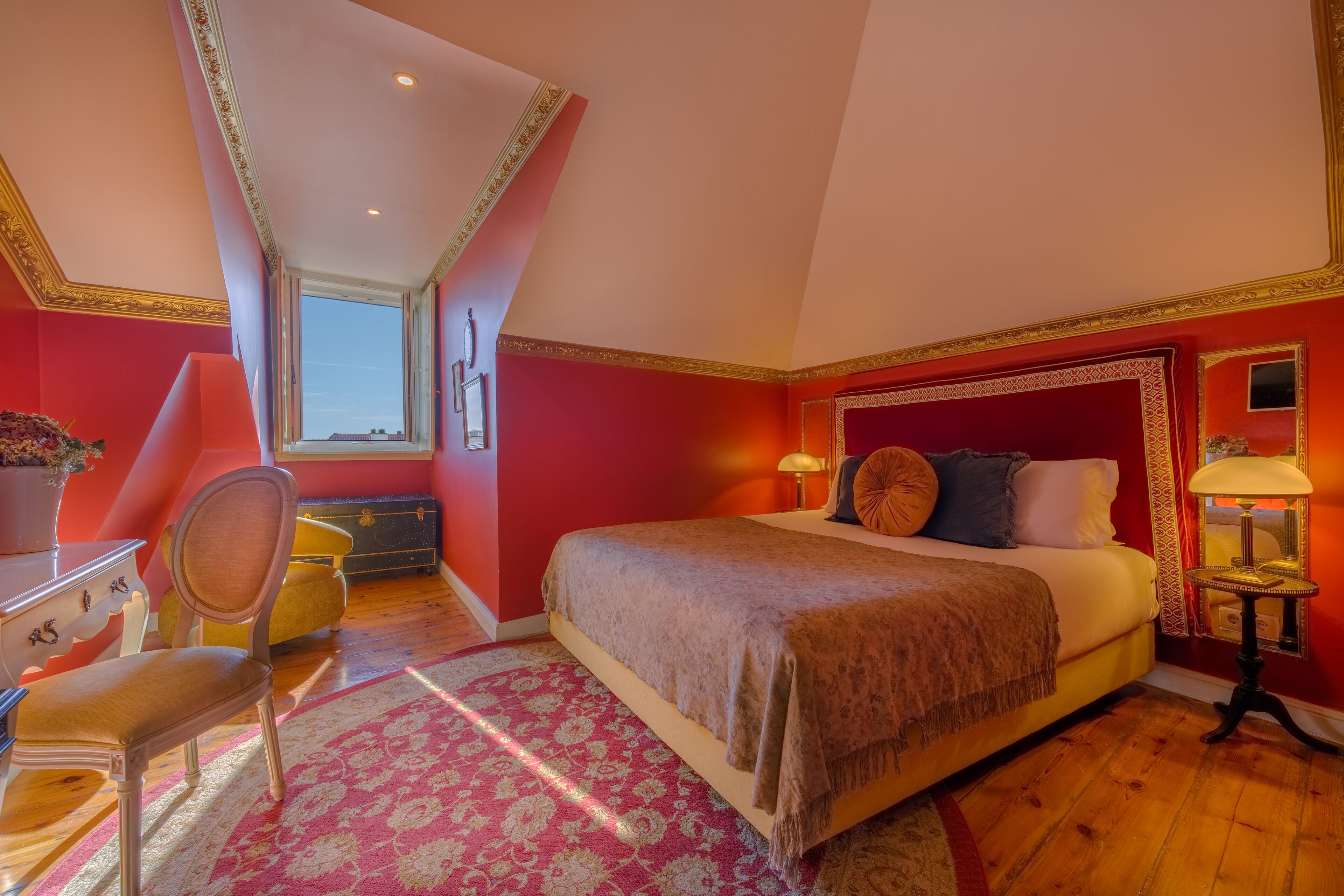 A bedroom with a large bed, a desk, and a chair.