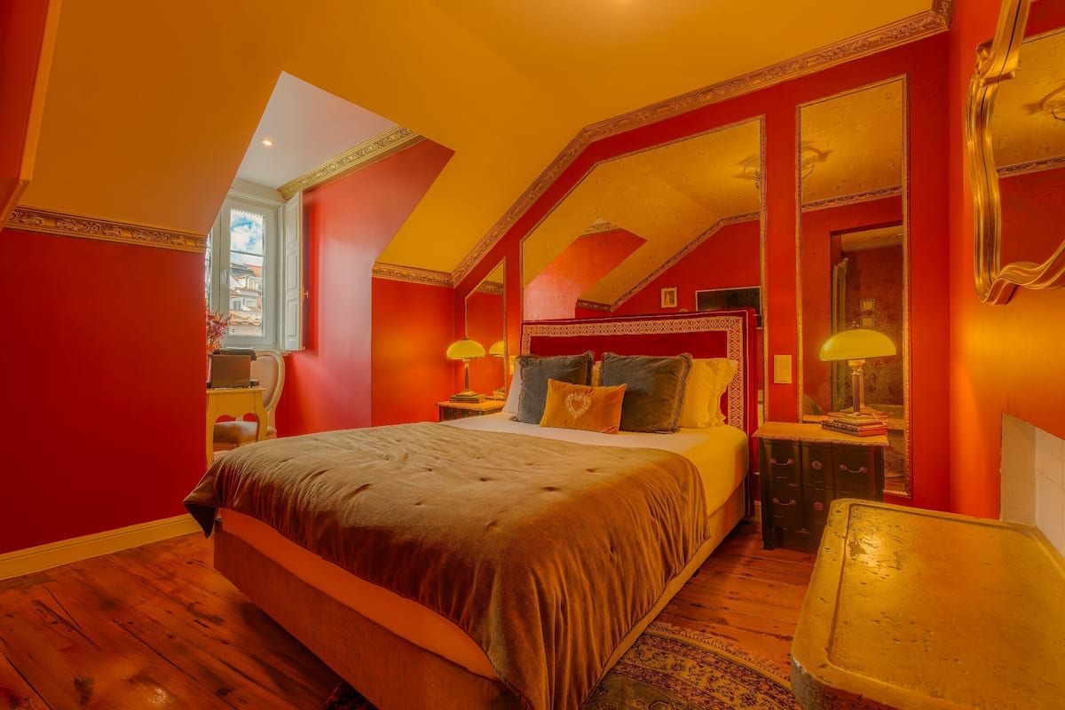 Une chambre à coucher avec un grand lit, une table de chevet, une commode et un miroir.