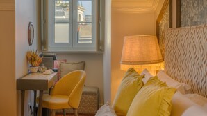 A hotel room with a bed, a desk, a chair, a lamp, and a window. - Solar dos Poetas (Lisbon)