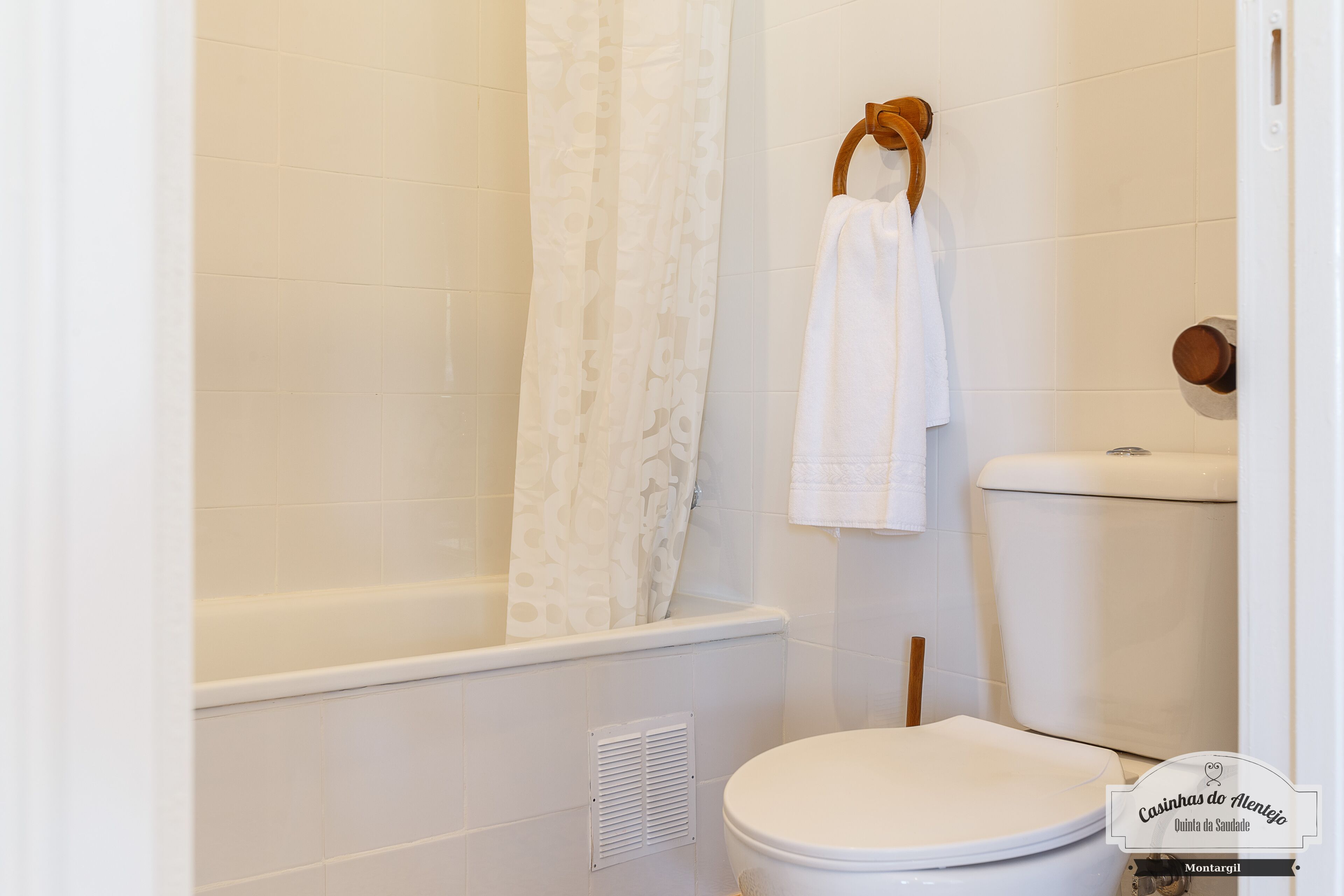 Un baño con bañera, inodoro y cortina de ducha.