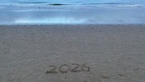 Een strand met het jaar '2026' in het zand geschreven.