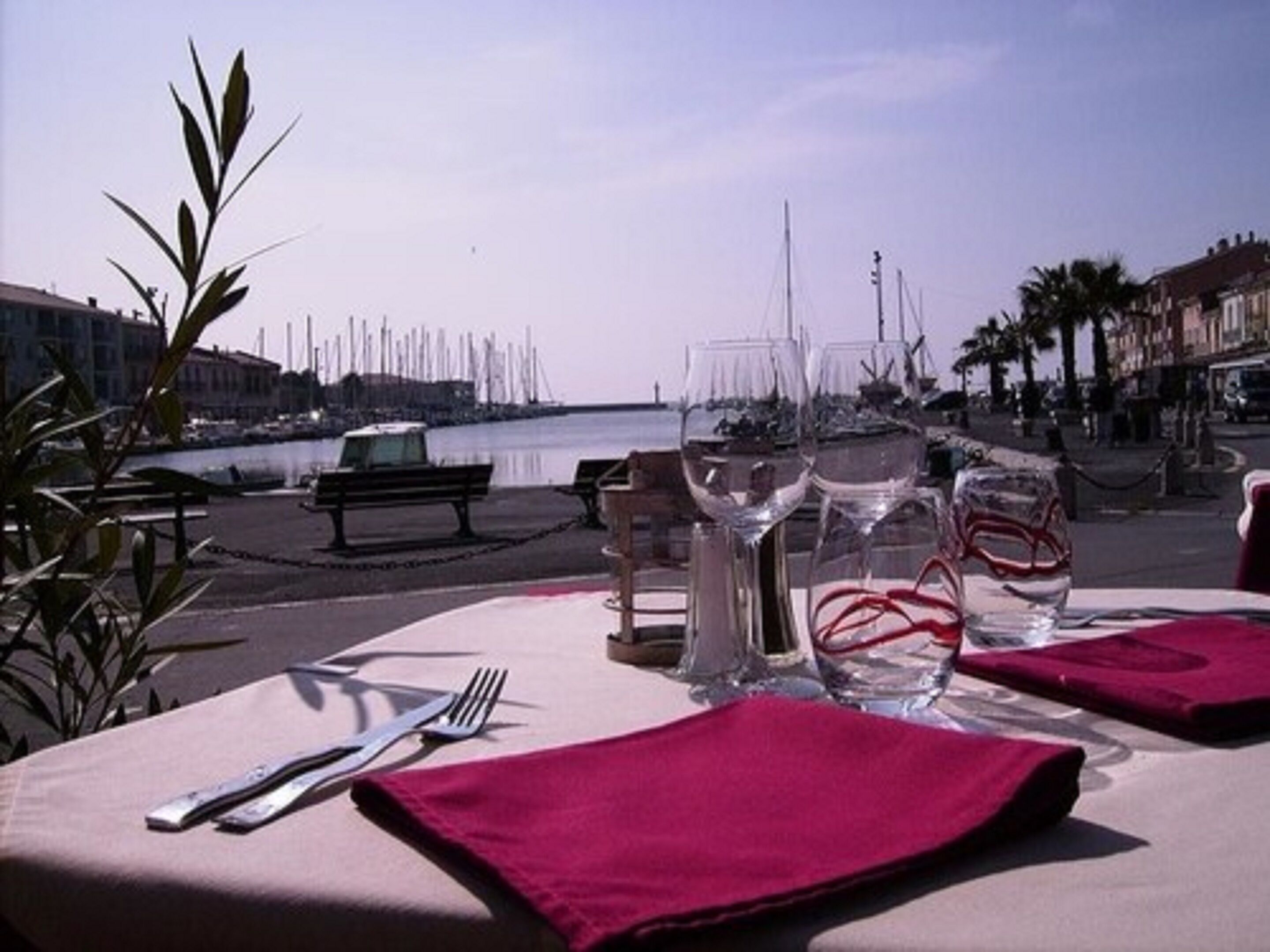 Tavola imbandita per due con vista sul mare e sugli edifici sullo sfondo.