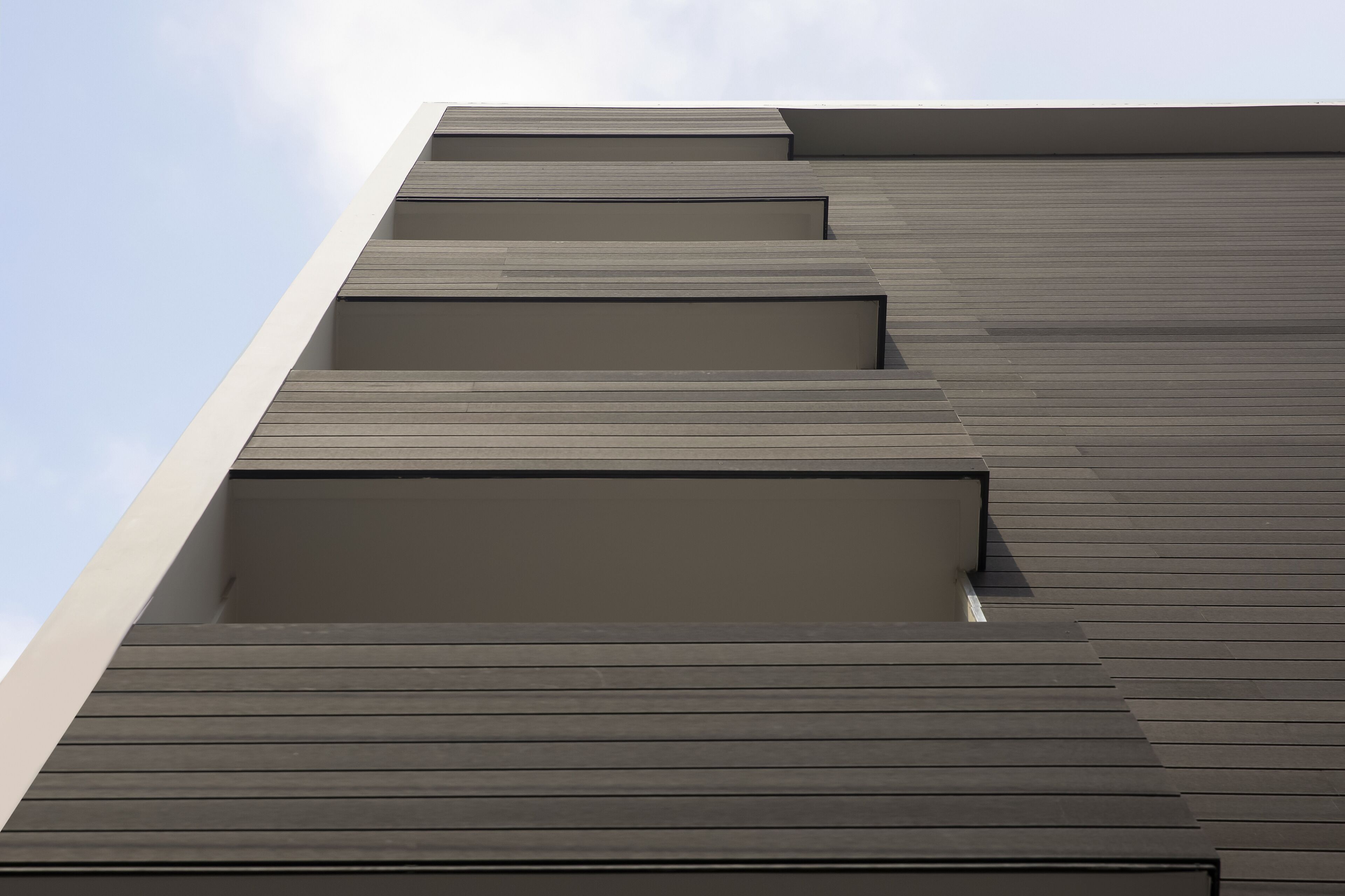 A modern building with a series of horizontal wooden panels and a flat roof.