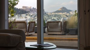 Una sala de estar moderna con vistas a un paisaje urbano y ruinas antiguas.