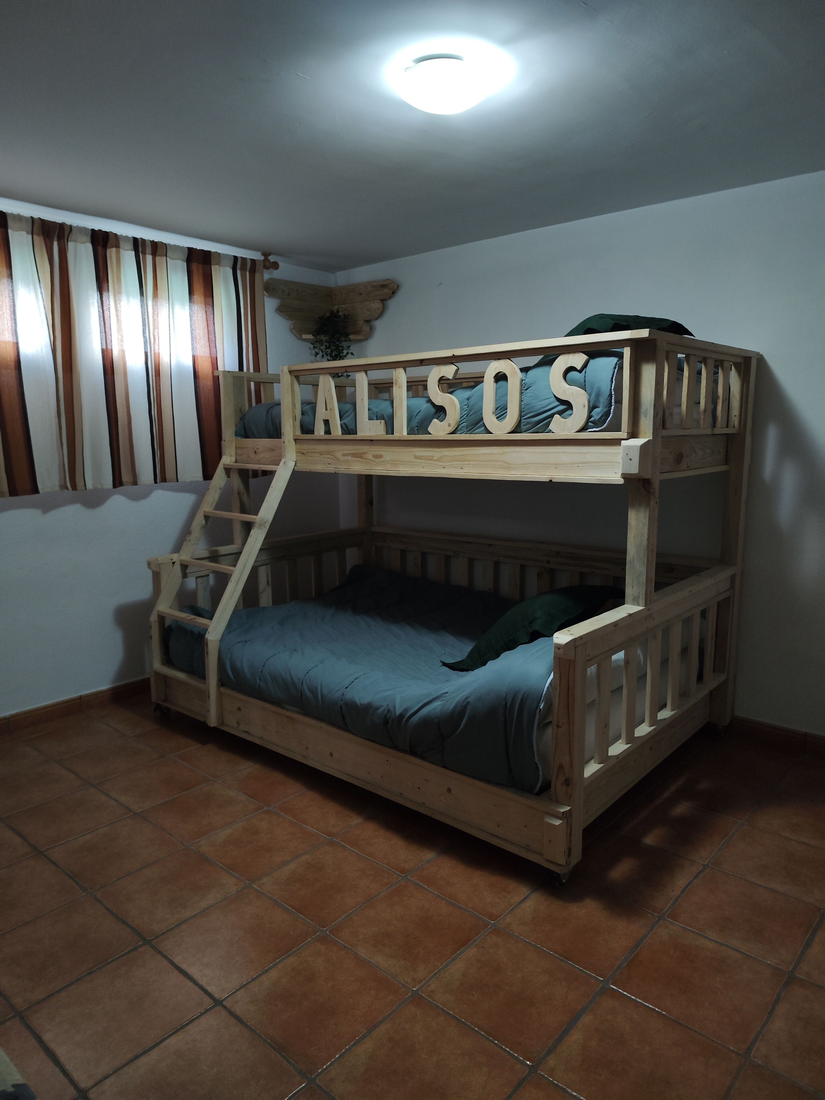 A bunk bed with the name 'ALISOS' on the top bunk.