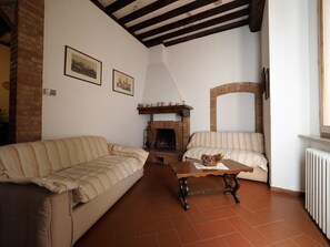 Fireplace, books - San Gimignano: ancient house renovated in the heart of San Gimignano (San Gimignano)