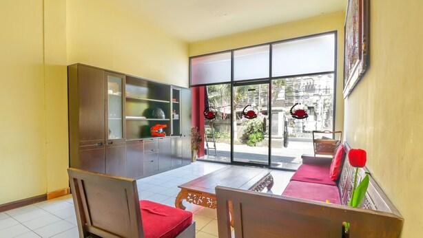 Una sala de estar con sofá, sillas, una mesa de centro y un aparador.