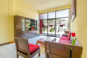 A living room with a sofa, chairs, a coffee table, and a cabinet. - OYO 1684 Marina Suite Apartment Bali (Denpasar)