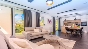 Una sala de estar moderna con un sofá, una mesa de centro y un comedor con sillas.