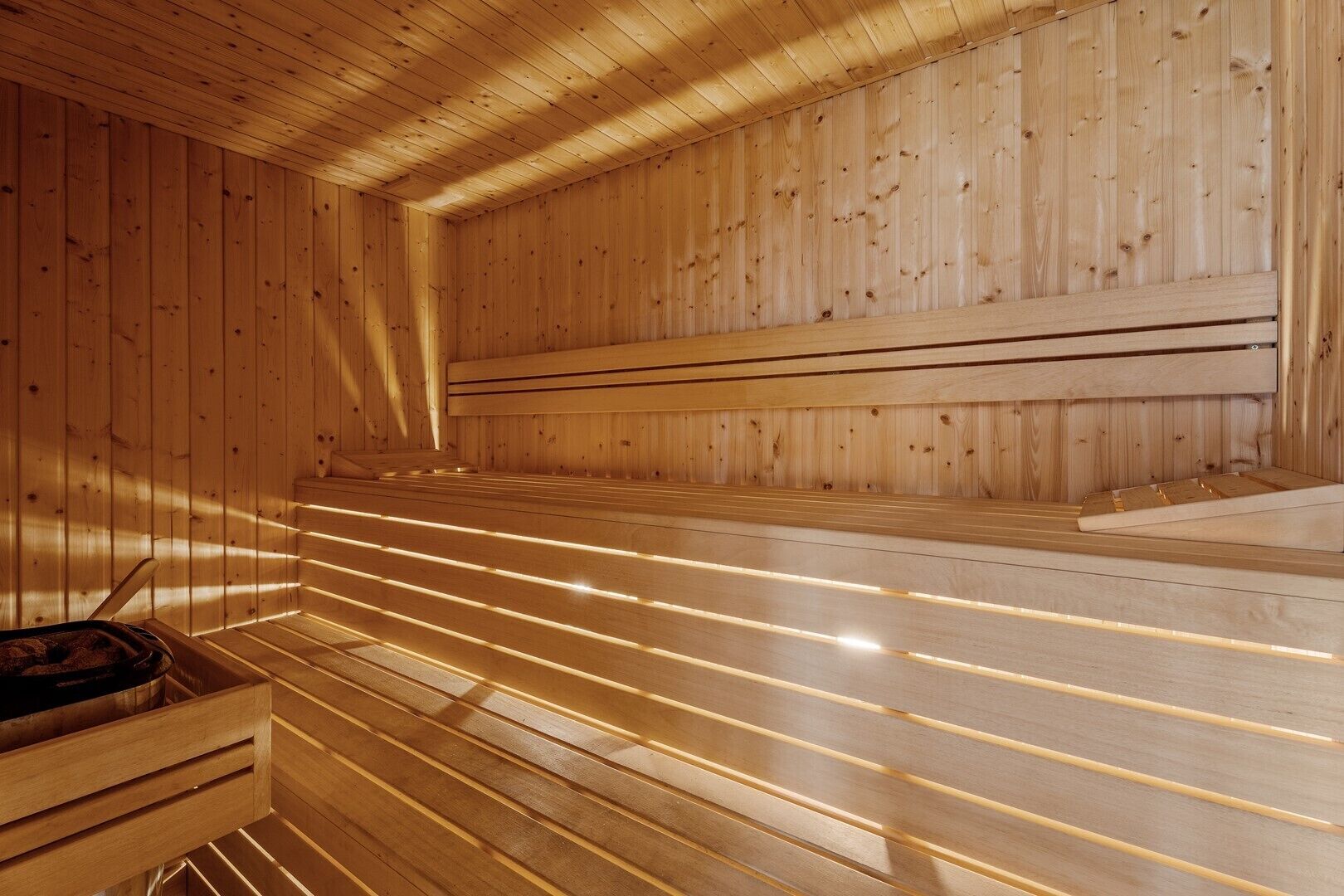 Un sauna avec des murs et des bancs en bois, et un banc sur lequel est posée une serviette.