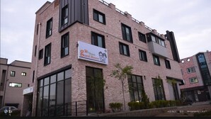 A multi-story building with a prominent sign for a guest house. - We Home Guesthouse - Hostel (Incheon)