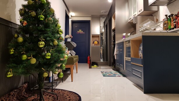 A modern kitchen with a built-in oven, a sink, and a countertop with various items. - We Home Guesthouse - Hostel (Incheon)