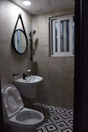 Un baño con inodoro, lavamanos y ducha.