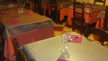 Ein Restaurant mit karierten Tischdecken, Holzkästen und bereitgestellten Weingläsern.