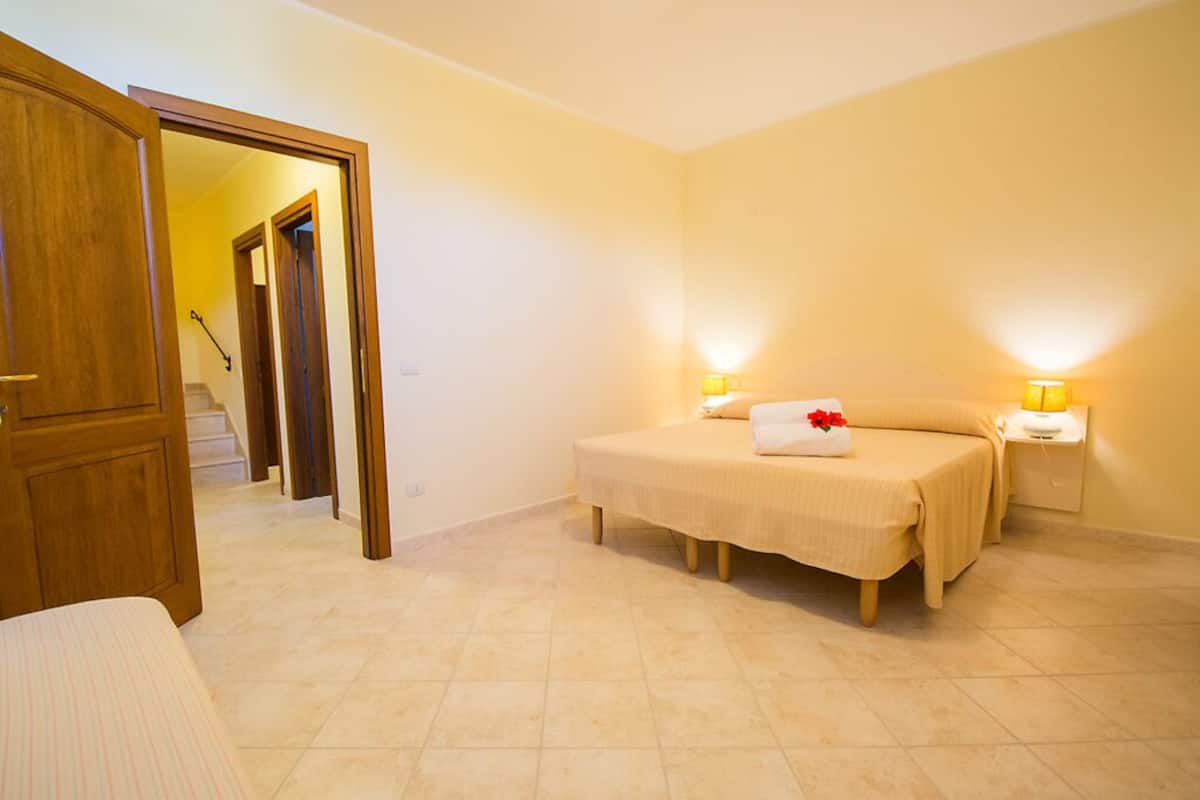 Une chambre à coucher avec un lit, des lampes de chevet et une porte en bois.