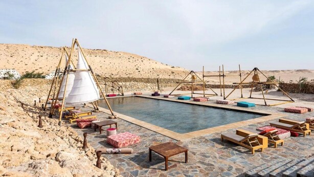 A pool area with lounge chairs and a tent structure. - Les Dunes de Dakhla (Dakhla)
