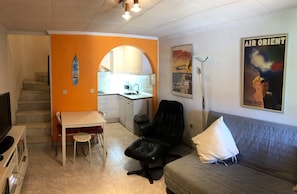 A compact living space with a kitchenette, a dining area, and a seating area.