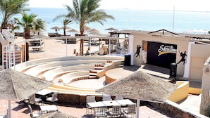 A beachside outdoor theater with a stage, seating, and a view of the sea. - Eagle's Paradise Beach Resort Abu Soma (Safaga)