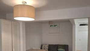 A compact living space with a wooden desk, a sofa, and a wardrobe. - Nomad's Castel Lisbon - 1-Bedroom "The Traveler" (Lisboa ciudad)