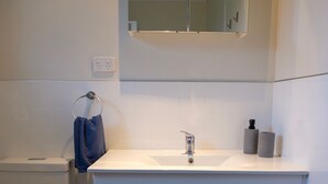 A bathroom with a white sink, mirror, and toilet. - Poppa's Place: Safe & secluded, close to Lake Taupo & Tongariro (Omori)
