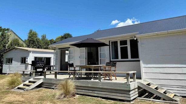 A white mobile home with a patio area featuring a table and chairs, a grill, and a covered seating area. - Poppa's Place: Safe & secluded, close to Lake Taupo & Tongariro (Omori)