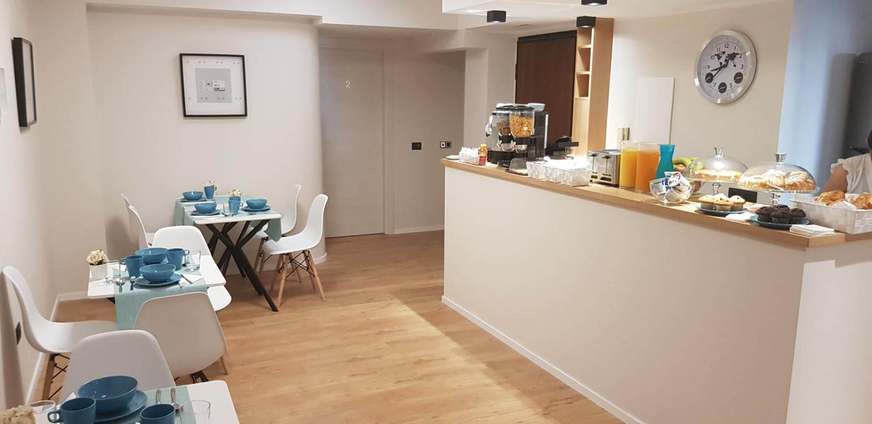 A modern kitchen with a breakfast bar, a coffee machine, and various food items.