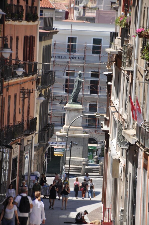 A street scene with a statue, buildings, and pedestrians. - Eva Luxury Rooms Cagliari (Cagliari)