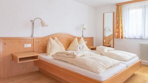 A wooden bed with a headboard, bedside tables, and lamps.