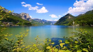 A lake surrounded by mountains, with a small building on the right side.
