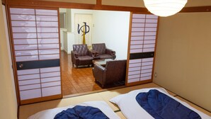 Una habitació japonesa tradicional amb terra de tatami, un panell shoji i un llit futón.