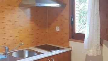Frigorífico pequeño, placa de cocina y utensilios de cocina