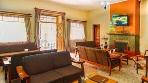 A living room with sofas, a fireplace, and a television. - Olive Resort (Naivasha)