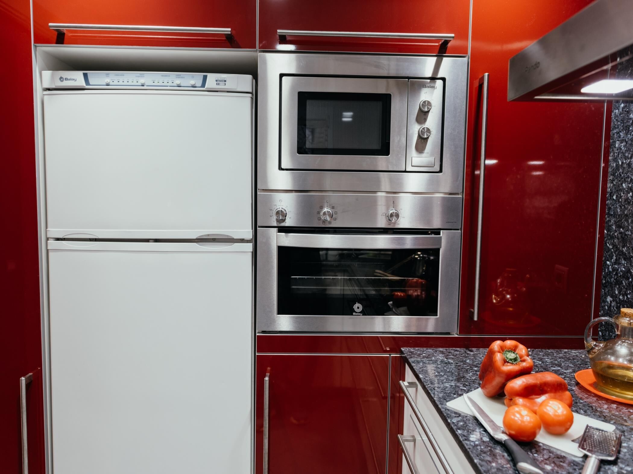 A kitchen with a white refrigerator, a built-in oven, and a microwave.