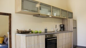 Une cuisine moderne avec des meubles en bois, un four encastré et une machine à café.