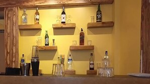 Eine Bar mit Holzböden, auf denen verschiedene Flaschen und Gläser stehen.