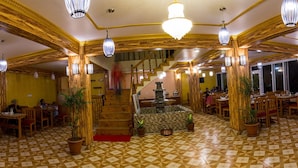 Ein Restaurant mit Schachbrettboden, Holzbalken und hängenden Lampen.