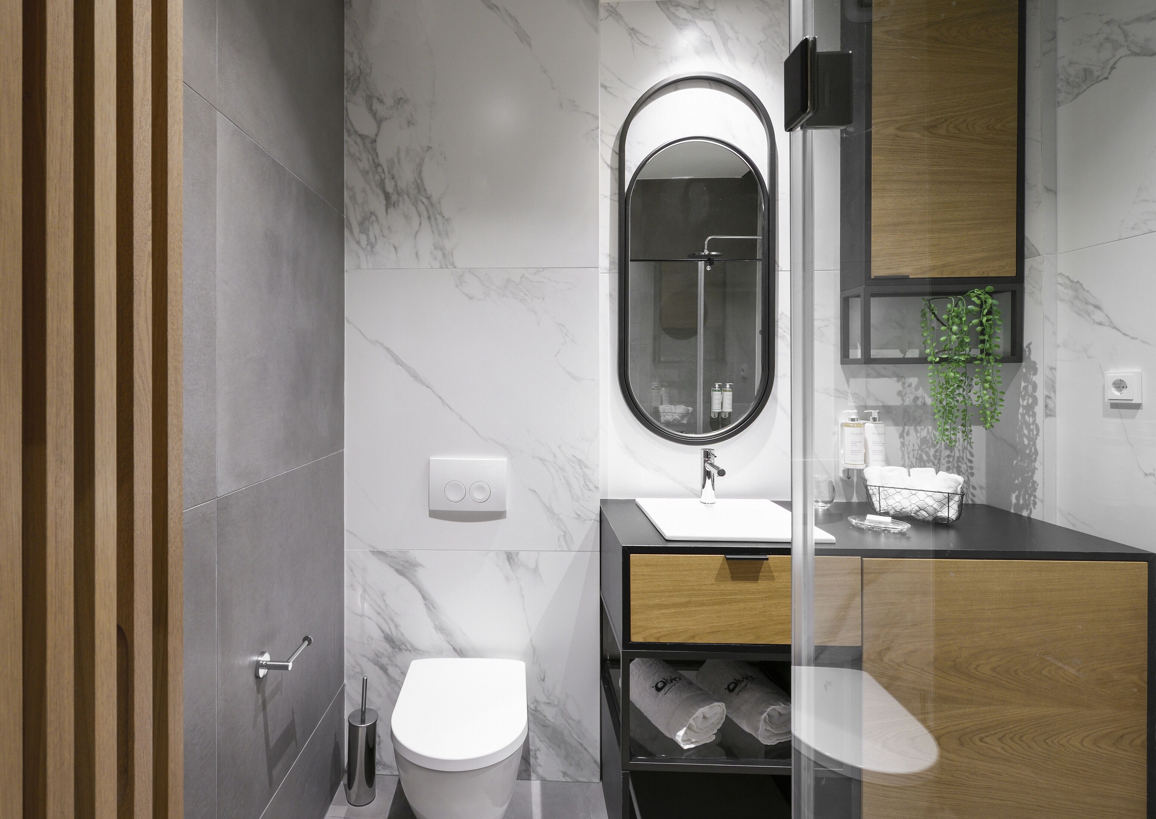 A modern bathroom with a toilet, sink, and shower.