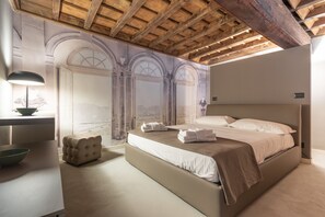 A bedroom with a large bed, a bedside table with a lamp, and a wall mural. - City Center Quadrilatero Romano (Turin)