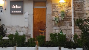 Un edificio con un letrero que dice 'Le Maison Bed and Breakfast' y una puerta de madera.