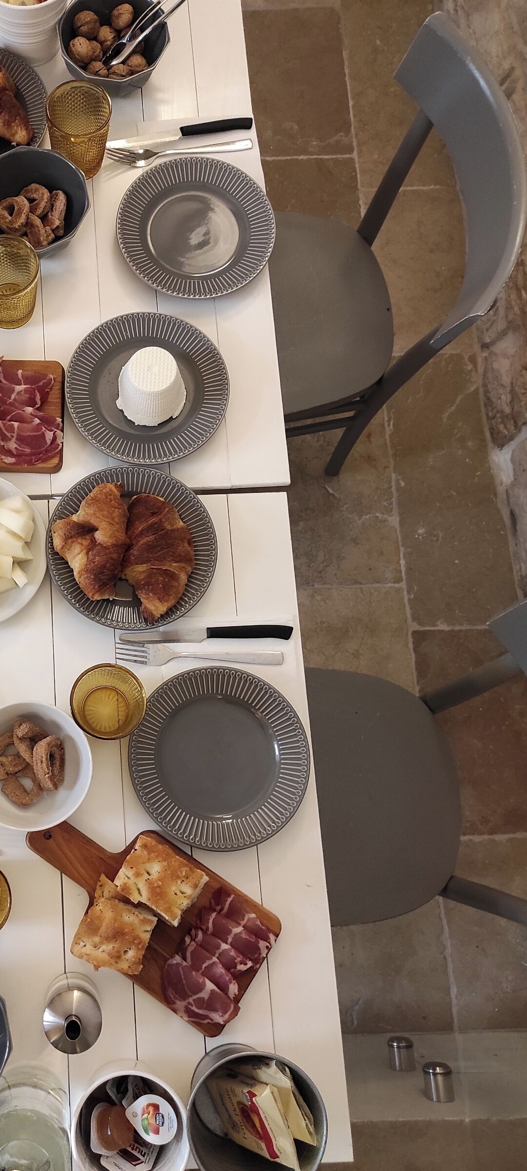 A dining table with plates of food, utensils, and a glass of water.