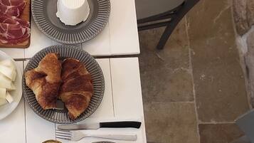 A dining table with plates of food, utensils, and a glass of water.