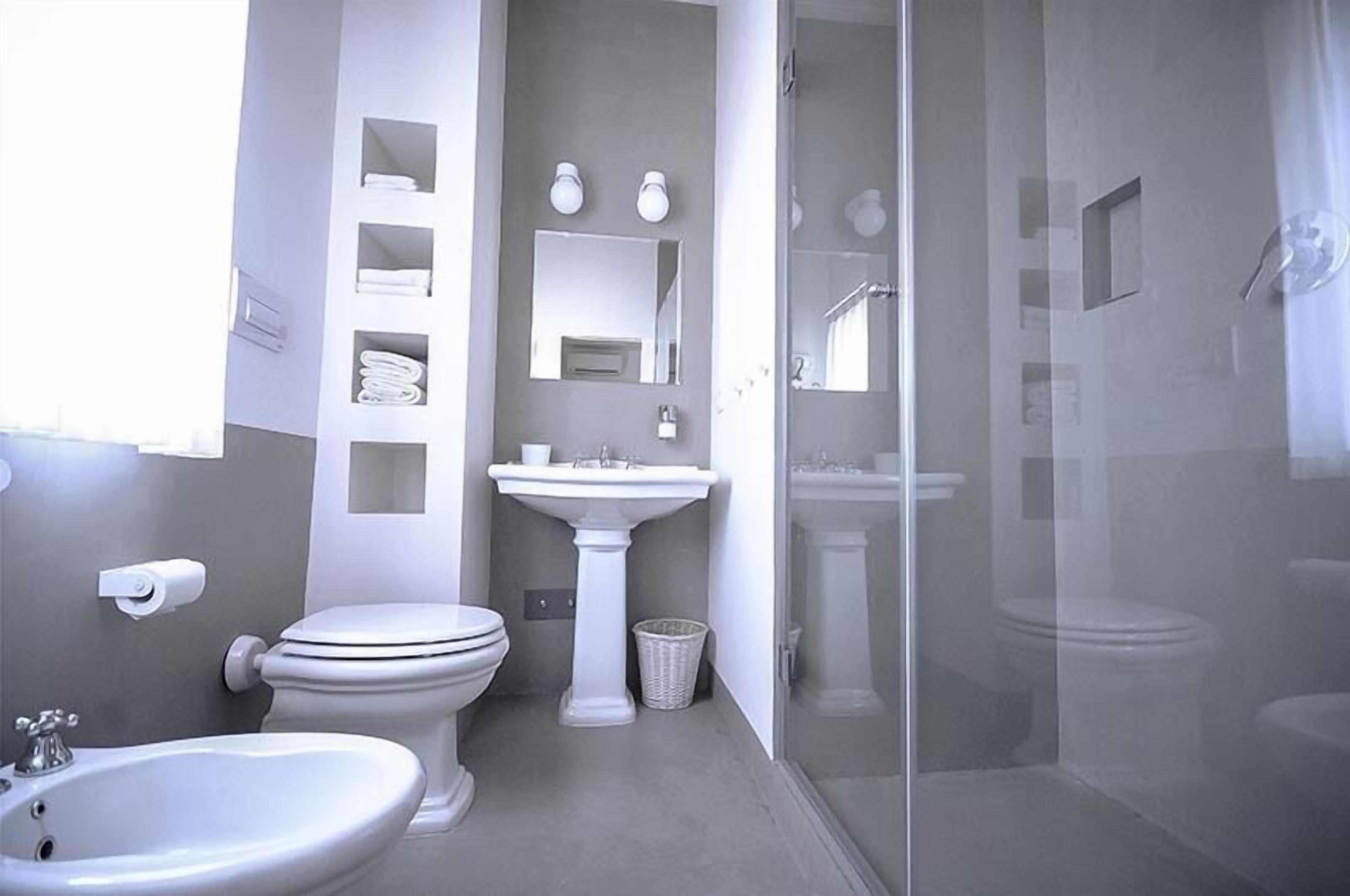 A modern bathroom with a toilet, sink, and shower.